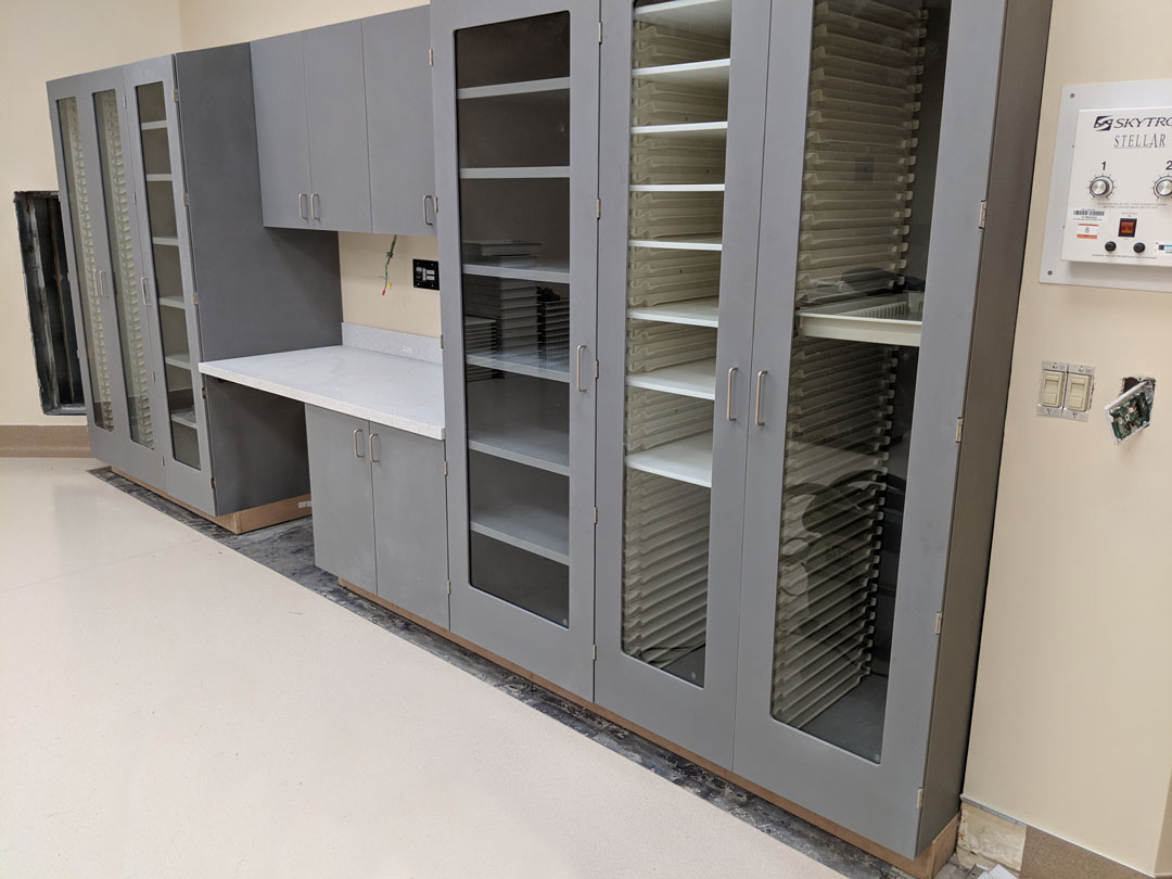 Shield Casework healthcare acrylic solid surface cube line cabinets in operating room with grey finish, high density storage, and sloped tops